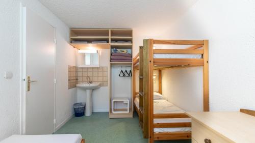 a small room with bunk beds and a sink at Vacancéole - Résidence Les Gorges Rouges in Guillaumes