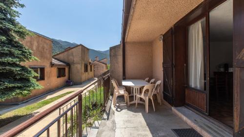 an outdoor patio with a table and chairs on a balcony at Vacancéole - Résidence Les Gorges Rouges in Guillaumes