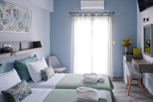 a blue bedroom with a bed and a window at Liprando in Naousa