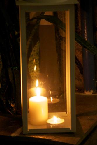 a candle in a glass box with a mirror at Galini Pension in Ios Chora