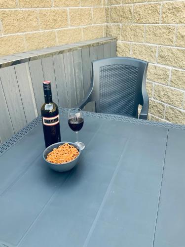 a bottle of wine and a bowl of peanuts and a glass of wine at Ubytování V Zátiší Lednice in Lednice