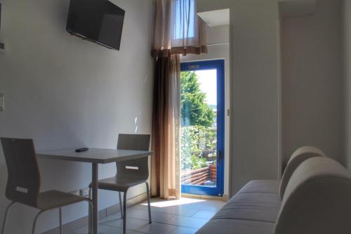 a room with a bed and a table and a window at Time Out ApartHotel in Casalecchio di Reno