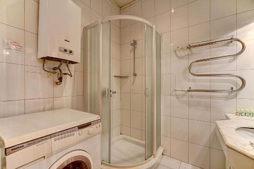 a bathroom with a shower and a washing machine at STN Apartments Budget in Saint Petersburg