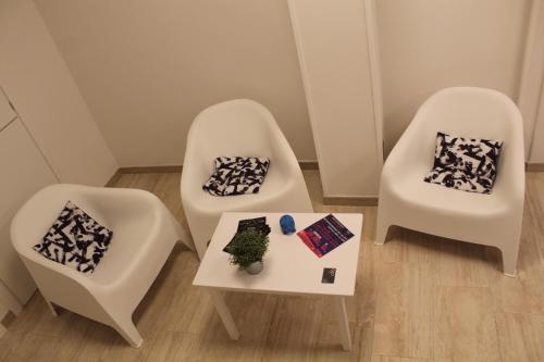 two white chairs and a table in a room at Time Out ApartHotel in Casalecchio di Reno