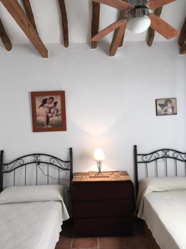 Un dormitorio con dos camas y un ventilador de techo. en Casa Baños, en Manilva