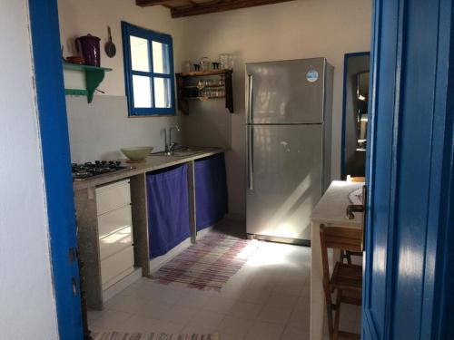 a kitchen with blue cabinets and a stainless steel refrigerator at BLU DIPINTO DI BLU in San Vito lo Capo