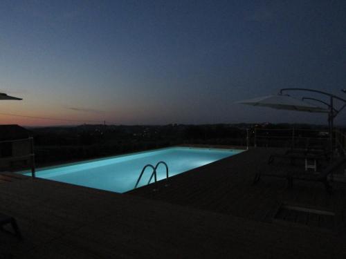 a swimming pool at night with a view at B&B La Gibiana in Costigliole dʼAsti
