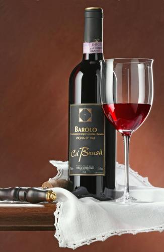 a bottle of wine and a glass of red wine at Agriturismo Ca' Brusà in Monforte dʼAlba