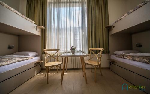a hotel room with a table and two beds at Armenian Inn in Yerevan