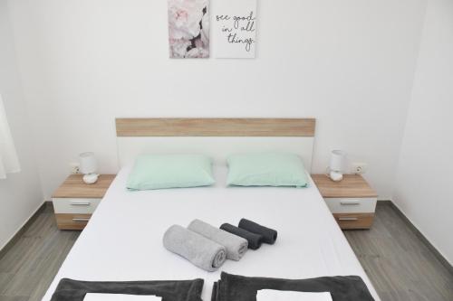 una camera da letto con un letto bianco e asciugamani di Apartments Mino a Ražanac (Rasanze)