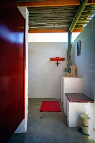 a room with a red door and a red rug at Kalahari Camelthorn Guesthouse and Camping in Askham