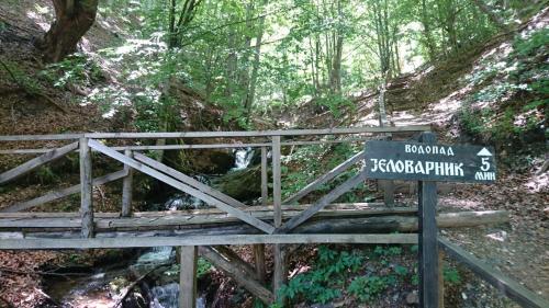 a sign on a wooden trail in a forest at GOski Apartman Brzeće Kopaonik in Brzeće