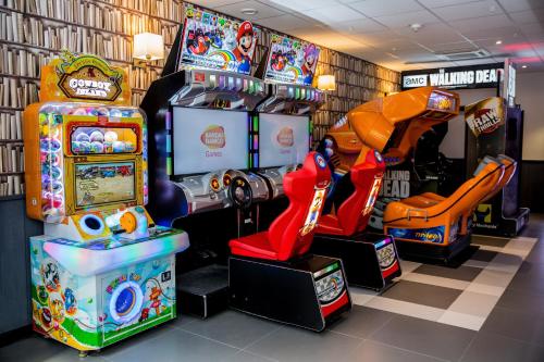 a room with several arcade games on display at Campanile Val de France in Magny-le-Hongre