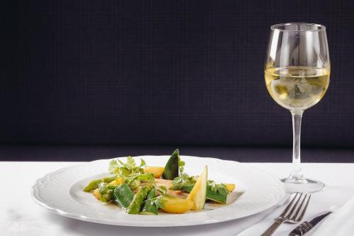 a white plate of food and a glass of wine at Pateo dos Solares Charm Hotel in Estremoz