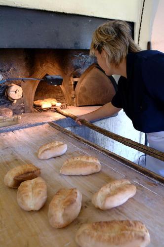 a woman is making bread in an oven at Agriturismo Ca' Brusà in Monforte dʼAlba