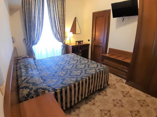 a bedroom with a blue bed and a window at Hotel Mariano in Rome