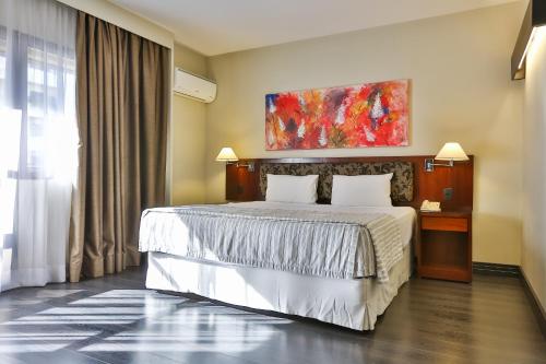 a bedroom with a bed and a painting on the wall at Double Tree by Hilton São Paulo Itaim in Sao Paulo