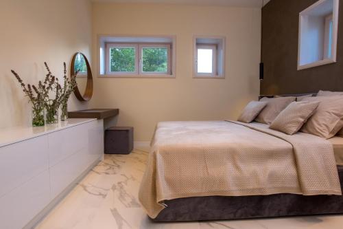 a bedroom with a large bed and a mirror at Apartmani Paklenica Noa in Starigrad-Paklenica