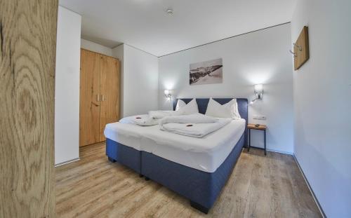 a bedroom with a blue and white bed and a wooden floor at AlpenParks Hotel & Apartment Sonnleiten in Saalbach Hinterglemm
