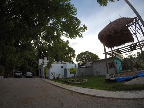 a small white house with a straw roof at Casa CheJum Bacalar in Bacalar