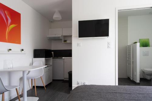 Cette chambre comprend un lit, une table et une cuisine. dans l'établissement Studio indépendant chez l’habitant au calme, à Dompierre-sur-Yon