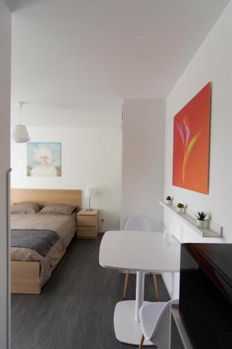 une chambre avec un lit, une table et un bureau dans l'établissement Studio indépendant chez l’habitant au calme, à Dompierre-sur-Yon