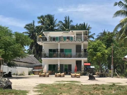 a large white building with tables and chairs at Homaja Roomrental in Panglao