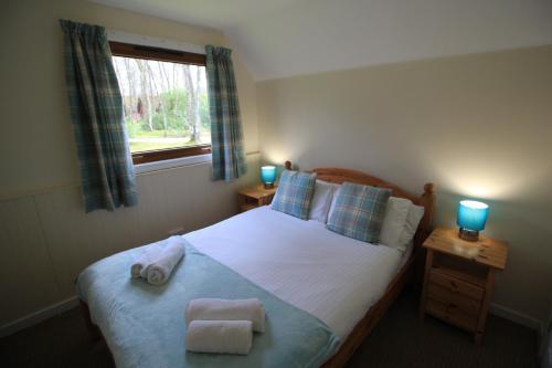 Säng eller sängar i ett rum på Burnbank Lodges