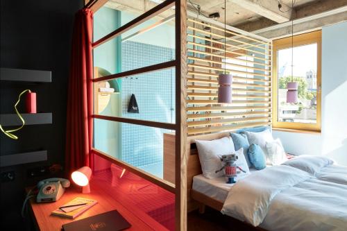 a bedroom with a bed and a large window at 25hours Hotel The Circle in Cologne