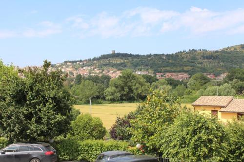 two cars parked in a parking lot with a hill in the background at Monolocale Azzurra in Magione