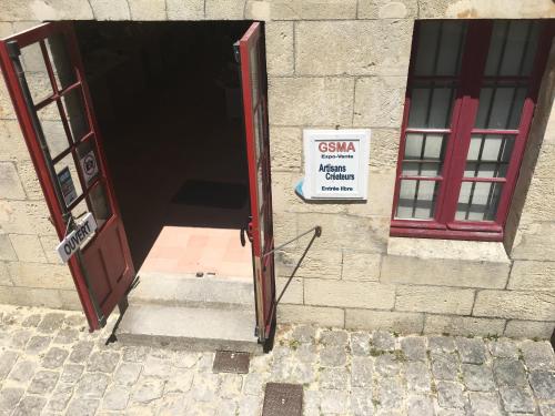 an open door with a sign in front of a building at Petit nid à 50m de la plage au coeur de Fouras in Fouras