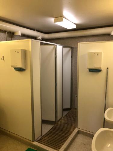 a bathroom with stalls with a toilet and a sink at Kesäaitat in Ähtäri