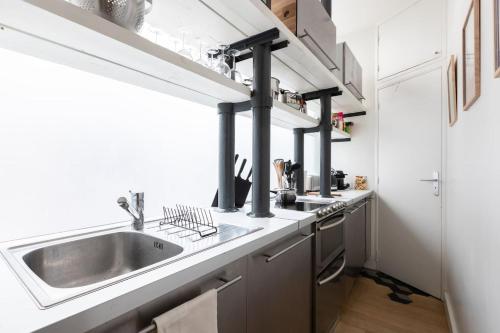 une cuisine avec un évier et une cuisinière dans l'établissement Fabulous Design Loft - High Marais/République, à Paris