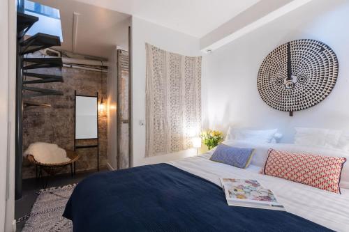 une chambre avec un grand lit avec une horloge au mur dans l'établissement Fabulous Design Loft - High Marais/République, à Paris