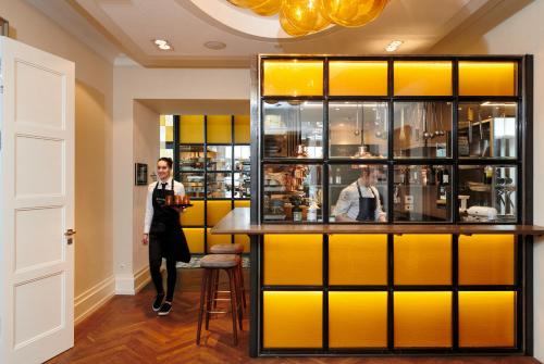 a man in a suit standing next to a bar at LA MAISON hotel & spa in Saarlouis
