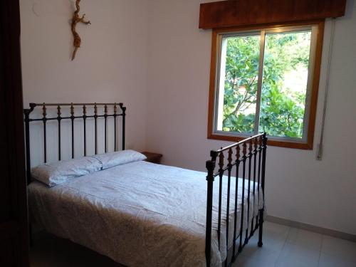 1 dormitorio con cama y ventana en Casa en Ribeira Sacra, en Viñoás