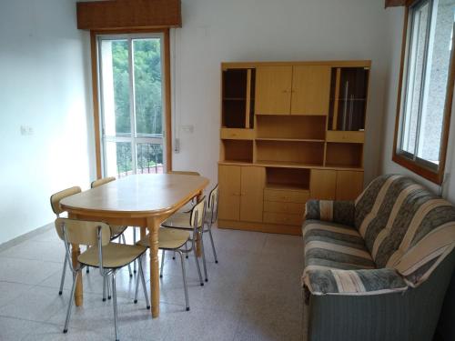 sala de estar con mesa, sillas y sofá en Casa en Ribeira Sacra, en Viñoás