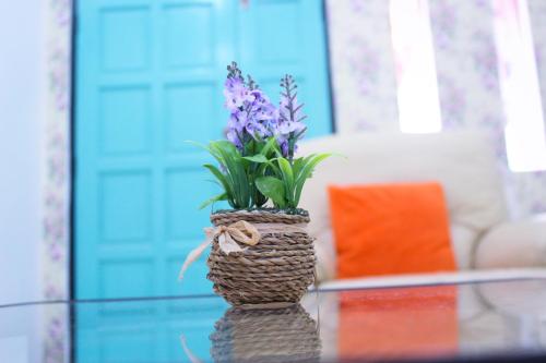 a vase with purple flowers sitting on a glass table at The Floral Home in Melaka