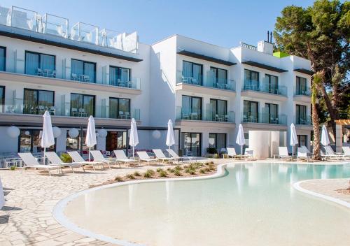 
a large white swimming pool in front of a large building at Sol i Vida Hotel - Adults Only in Porto Cristo
