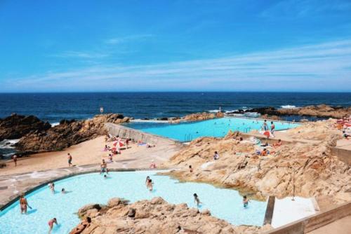 a group of people in a swimming pool on the beach at Apartamento Matosinhos Mar in Matosinhos