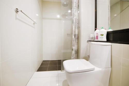 a white bathroom with a toilet and a shower at Cozy Living Sky Apartment in Kota Kinabalu