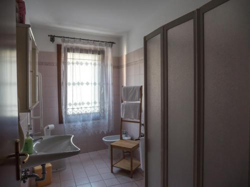 een badkamer met een wastafel, een toilet en een raam bij Agriturismo Ca' Marcello in Mira