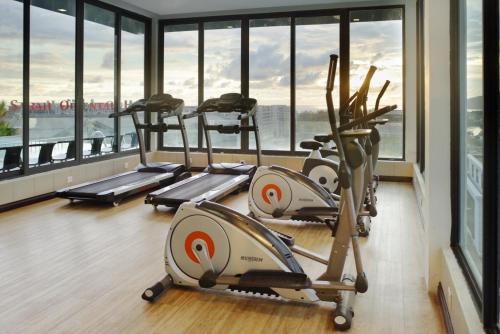 a row of treadmills in a gym with windows at Cozy Living Sky Apartment in Kota Kinabalu