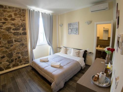 a bedroom with a bed and a stone wall at Vicolocorto Affittacamere in La Spezia