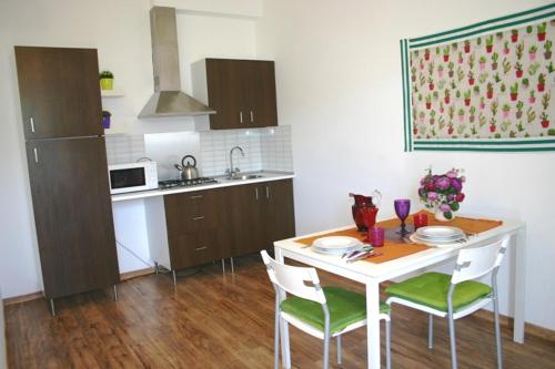 uma cozinha com uma mesa com 4 cadeiras e uma cozinha com em CASA LUCIA em Meta