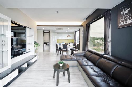 a living room with a leather couch and a table at Cozy Living Sky Apartment in Kota Kinabalu