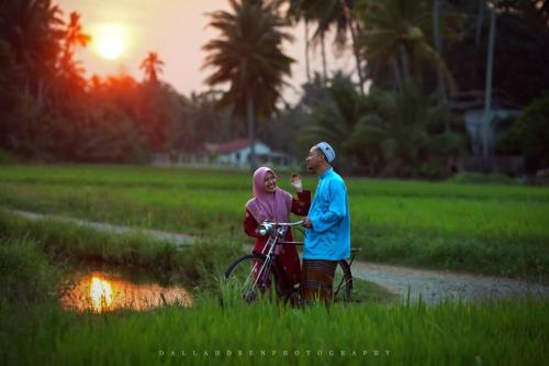 a man and a woman standing next to a bike at Seri Pengkalan Homestay in Bachok