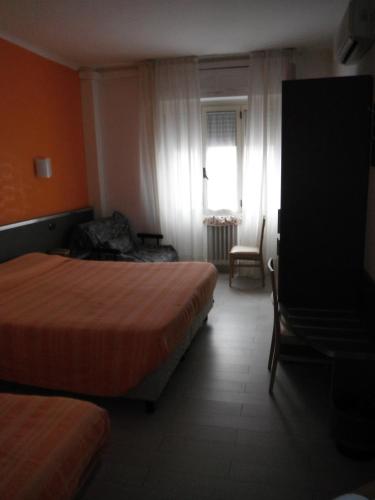 a hotel room with two beds and a window at Hotel Renato in Sesto San Giovanni