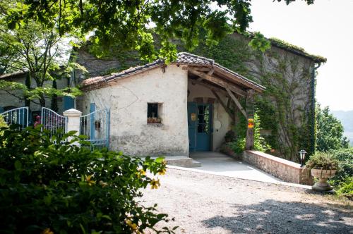 une maison avec une porte bleue et une allée dans l'établissement Les Huguets, à Villeneuve-sur-Lot
