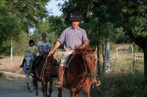 a man and a woman riding horses down a road at Les Huguets in Villeneuve-sur-Lot